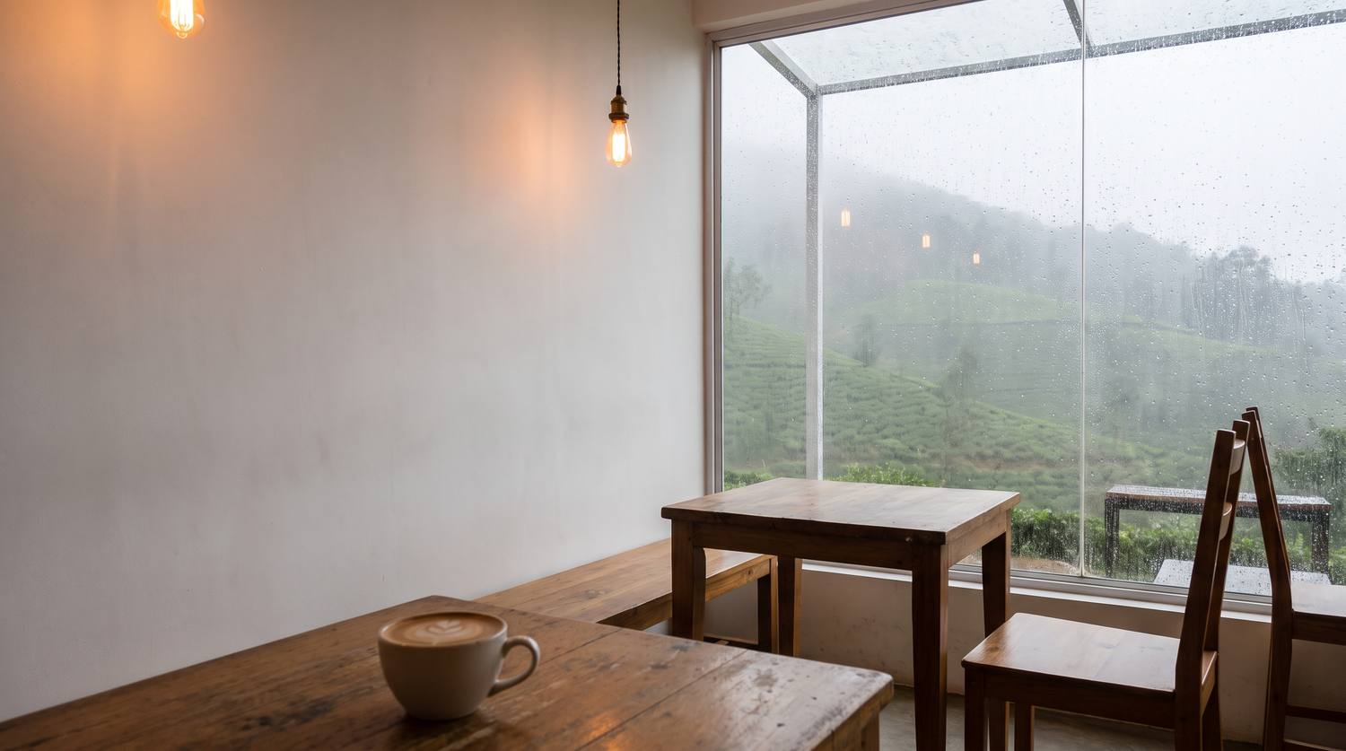 白い壁と大きな窓だけの、静かな雨の日のカフェ